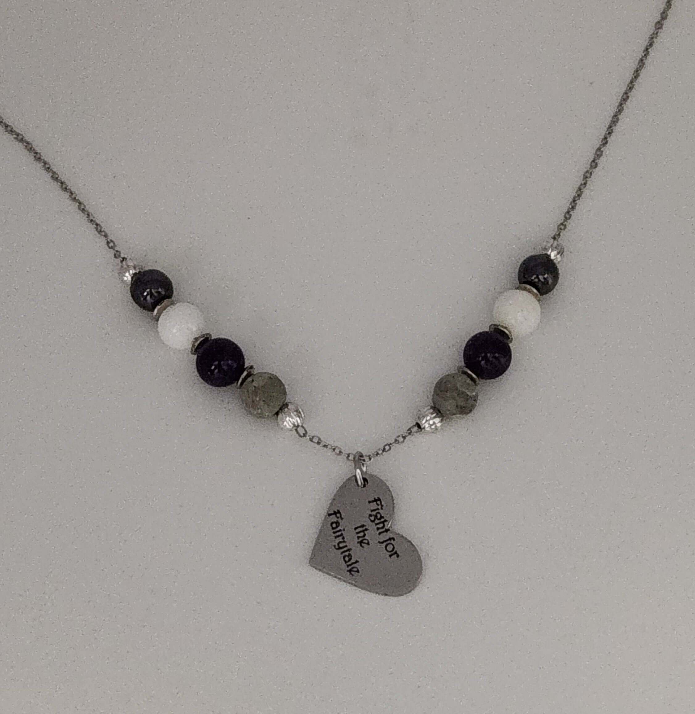 Celebrate identity with this demisexual pride necklace. Silver-plated, nickel-free stainless steel with a heart pendant engraved “Fight for the Fairytale.” Adjustable 18–20 inches.