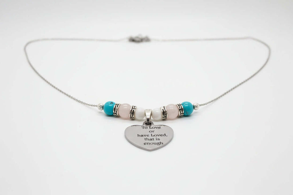 Premium transgender pride necklace featuring blue magnesite, rose quartz, and mother of pearl. Nickel-free, plastic-free, silver-plated stainless steel with engraved heart pendant.